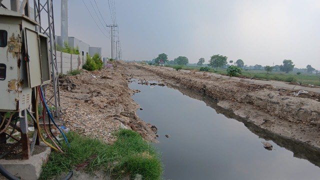 Drainage channel construction alongside the Gujjar Colony plant, carrying away water that previously pooled on the road