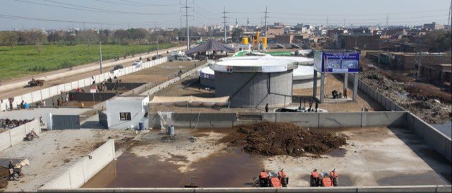 The Gujjar Colony plant with its digester tank and the manure reception area where daily deliveries arrive